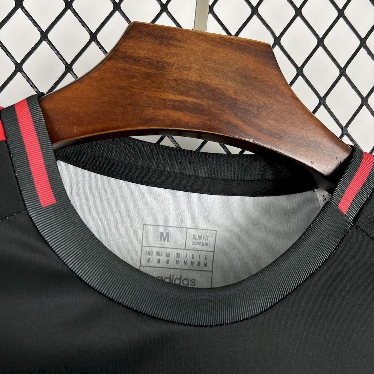 Camisola concept vermelha e preta com símbolo CINZA 2025/26